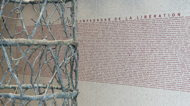 En arrière plan de la colonne de rameaux, figurent les noms des 1038 Compagnons de la Libération