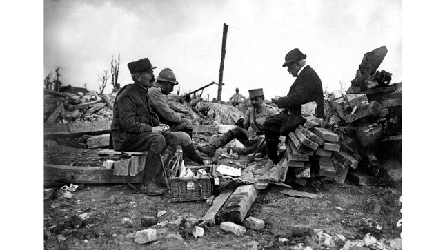 Le président Georges Clemenceau mangeant avec des soldats français dans les tranchées près de Maurepas (Somme) en 1917